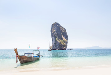 Fototapeta na wymiar Longtail boat mooring on the tropical beach with limestone rock symbol of Poda island is popular tourist destinations in the andaman sea krabi Thailand in sunny day