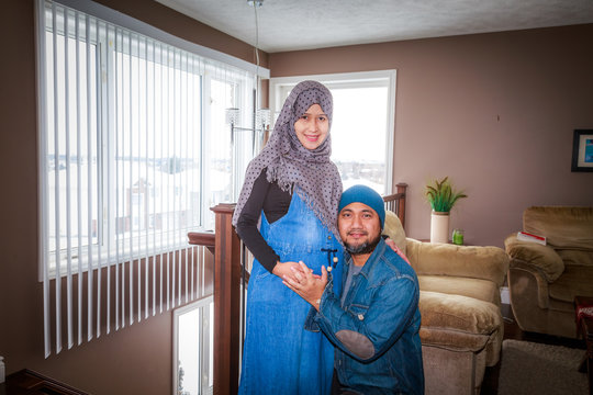 A Husband With His Pregnant Wife Inside Their Home During Winter In Canada