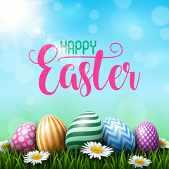 Colorful Easter eggs with daisies flowers on the grass