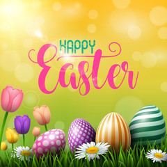 Happy Easter eggs with tulip flowers on meadow background