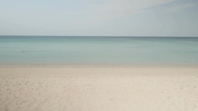 Happy couple playing with frisbee flying disc on the beach during sunny summer day