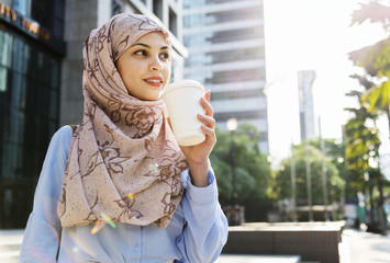 Islamic woman drinking coffee in the city