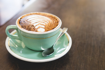 Caffe Latte with latte art in green coffee cup