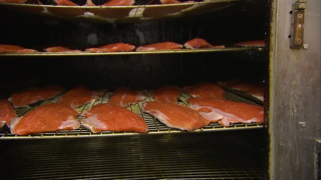 A medium shot of a smoking equipment with salmon inside.