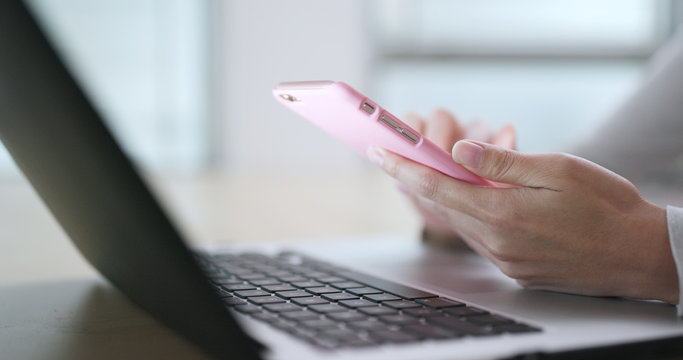 Woman use of mobile phone and notebook at home