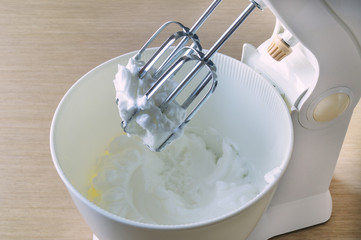 Fototapeta na wymiar Bowl with wipped cream and mixer
