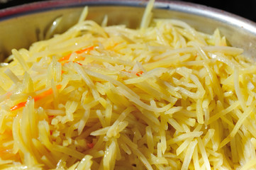 cooked sliced potato and carrots in container