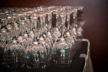 Wine glasses in a row at a bar.