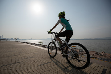 Fototapeta na wymiar sportswoman cyclist riding mountain bike on seaside