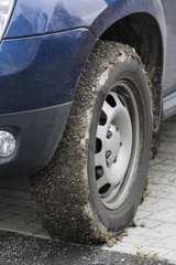 Putting mud and stones on car tires.