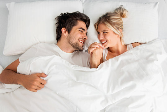 Young Loving Couple Lying On The Bed, Enjoying