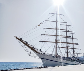White three-mast ship or frigate anchored at blue sea background © lilkin