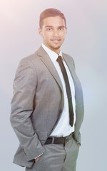 Young successful businessman smiling over grÑy background.