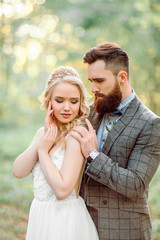 Fototapeta premium Beautiful young couple. The bearded groom hugging the bride.