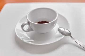 Closeup of white cup with black instant coffee and spoon