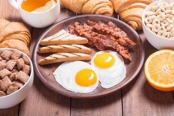 Breakfast with eggs , bacon and croissants