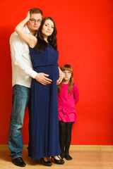 Fototapeta premium Pregnant woman, man and daughter posing.