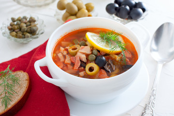 Traditional Russian soup Solyanka in a white serving cup, selective focus