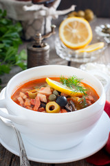 Traditional Russian soup solyanka closeup in a bowl on the table.