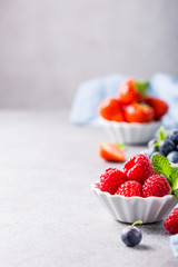 White ceramic bowl with fresh healthy berries. Raspberry, strawberry and blueberries. Copy space.