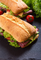 Ciabatta sandwich with lettuce , salami , cheese , avocado and tomatoes