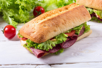 Ciabatta sandwich with lettuce , salami , cheese , avocado and tomatoes