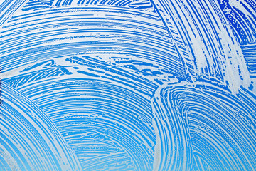 Window cleaning. Glass in soap foam against blue sky background - 198288777