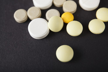 Tablets and capsules are scattered on the table