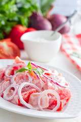 Vegetarian salad with fresh red tomatoes and red onions, selective focus