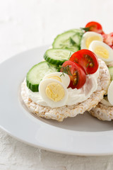 Open sandwiches of rice cakes with cream cheese , vegetables and quail egg