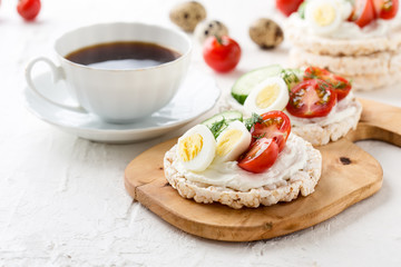 Open sandwiches of rice cakes with cream cheese , vegetables and quail egg