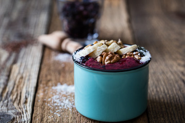 Smoothie mug with frozen blueberries, bananas, nuts, sunflower seeds and coconut flakes