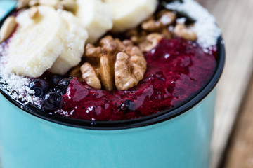Smoothie mug with frozen blueberries, bananas, nuts, sunflower seeds and coconut flakes