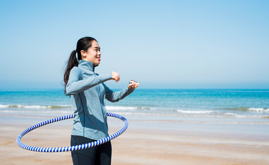 Girl exercising with hula hoop on the beach © creativefamily