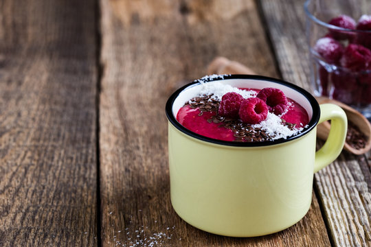 Smoothie mug with frozen raspberry,coconut flakes and flax seed