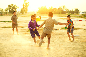 An action picture of a group of kids playing soccer football for exercise in community rural area.