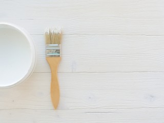 Paintbrush and can, paint brush and white color container on white wooden background , top view