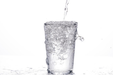 ein wasserglass wird mit sprudelwasser befüllt