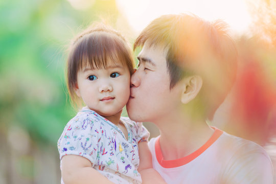 Portrait of good looking Asian people : father kiss his kid. Picture for concept of love, bonding and family.