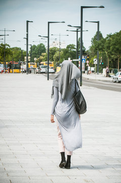Veiled Muslim woman walking in the street near the train station