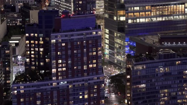 New York City low flying telephoto aerial view of Lower Manhattan Financial District buildings at night, including Goldman Sachs, Brookfield Place and World Trade Center Transportation Hub