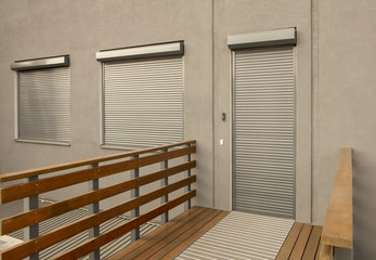 Fototapeta premium Metal blinds on the doors and windows of the facade of the house