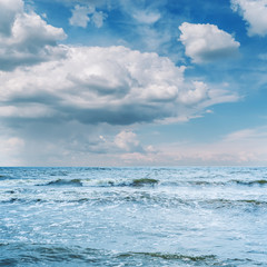 blue sea with waves and low clouds