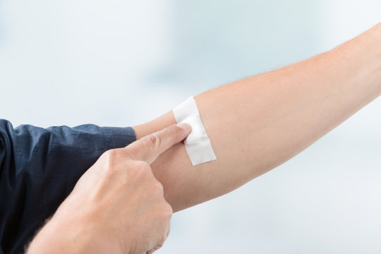 Pflaster am Arm eines Mannes nach der Blutentnahme