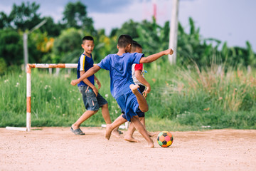 Obraz premium An action picture of a group of kids playing soccer football for exercise in community rural area.