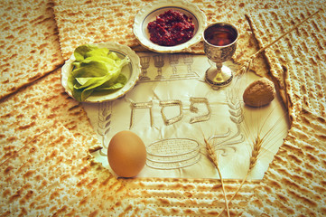 Pesah celebration concept (Jewish Passover Holiday) with traditional kosher food. Three Hebrew letters on napkin mean festive ceremony of holiday dedicated to the exodus from servitude