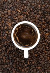 Cup of coffee on the coffee beans background.