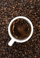 Cup of coffee on the coffee beans background.