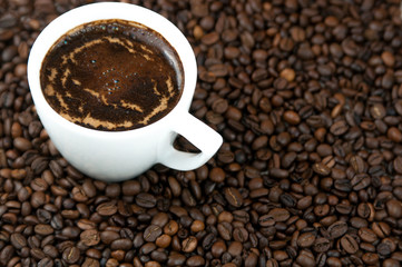 Cup of coffee on the coffee beans background.