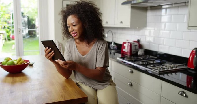 An attractive woman video chats on a digital tablet